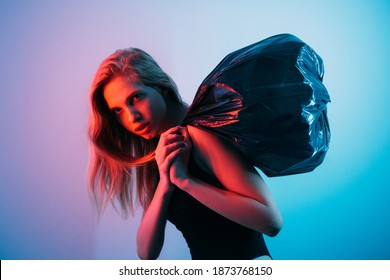 Art Portrait. Robbery Crime. Money Heist. Theft Fraud. Criminal Woman Stealing At Night Carrying Black Garbage Bag In Red Neon Light Isolated On Blue Pink Color Gradient Background.