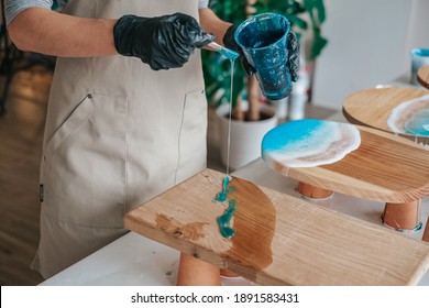 The art process of pouring epoxy resin into a wooden tray