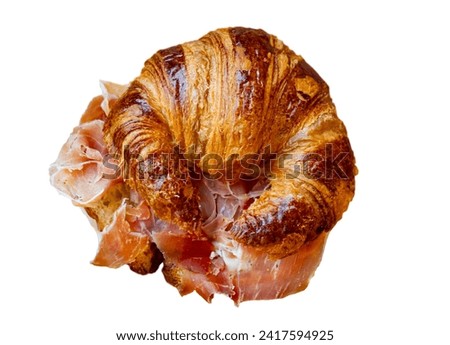 Art served appetizer on authentic wooden plate board - delicate puff pastry croissants with thin slices of ham in middle. Isolated over white background
