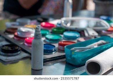 Art supplies arranged on a table with colorful paint containers and tools during an outdoor creative workshop session - Powered by Shutterstock