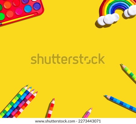Art supplies with a rainbow - overhead view - flat lay