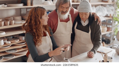 Art teacher, pottery and senior couple in a class, learning tips in art class. Young woman teaching old man and old woman to roll clay, sculpture and giving instruction in studio to learn new skill - Powered by Shutterstock