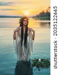 Art virgo zodiac. pagan girl Slavic goddess emerges from water lake, ritual flower wreaths candle float. Fashion model Fantasy woman witch enjoy summer sunset. Wet white vintage medieval nymph dress