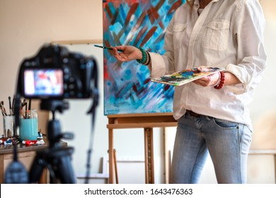 Art vlogger. Creative woman vlogging her painting technique and skill. Freelance artist recording video tutorial on camera