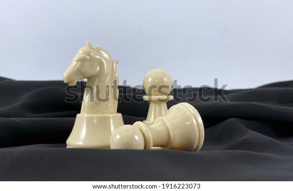 The Art of War. Chess as\
a business strategy concept. Fallen pawn protecting the knight.\
Pawn sacrifice. Strategy, leadership, success achievement,\
competition