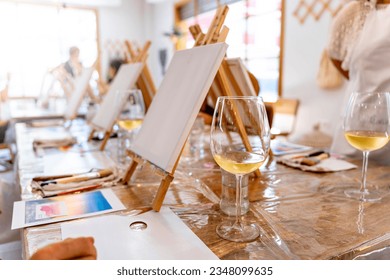 Art and Wine Workshop. White wine glasses with canvases to paint. - Powered by Shutterstock