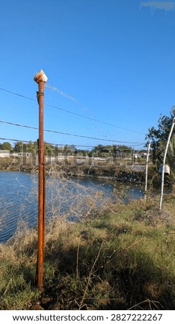 Artesian Well Pipe Gushing Water Near Pond