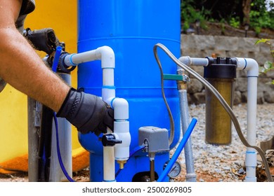 An artesian well system pump house is being connected to PVC water pipe