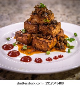 Artful Vegetarian Tofu Dish Stacked Neatly With Homemade Sauce And Diced Chives