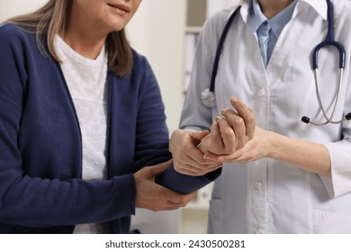 Arthritis symptoms. Doctor examining patient's wrist in hospital, closeup - Powered by Shutterstock