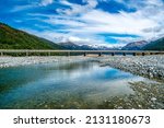 Arthurs Pass  bridge crossing the  Waimakariri River with a backdrop of the snow covered Southern alps mountain range