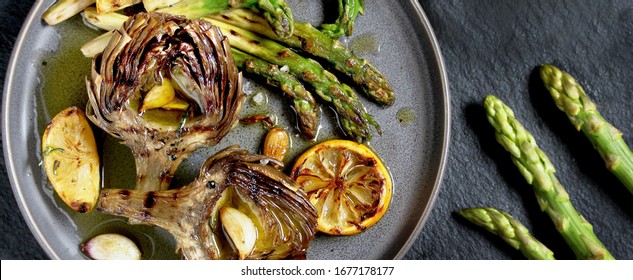 artichoke and asparagus grill. Tasty vegetables are first cooked for a couple, then fried on a grill, poured with olive oil and spices. spring vegetables.banner