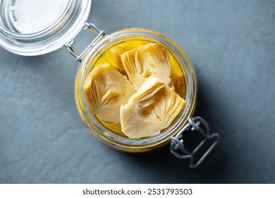 Artichoke hearts marinated in olive oil in glass jar. Close up. Top view. - Powered by Shutterstock