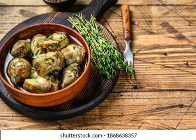 Artichoke hearts pickled in olive oil. wooden background. Top view. Copy space