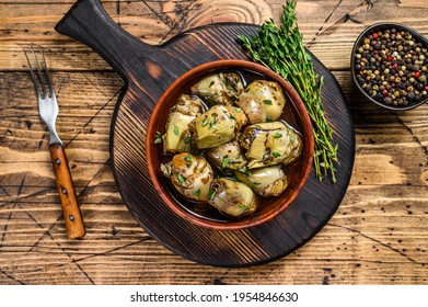 Artichoke hearts pickled in olive oil. wooden background. Top view