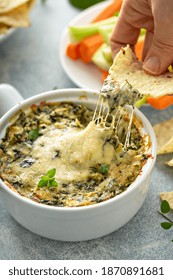 Artichoke Spinach Dip In A Baking Dish With A Cheese Pull