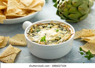 Artichoke spinach dip in a baking dish served with chips