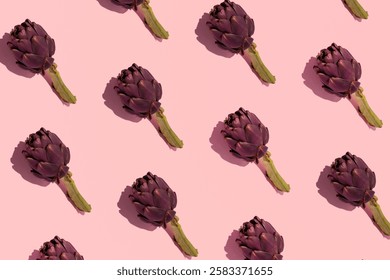 Artichokes, creative veggie pattern on pastel pink background.