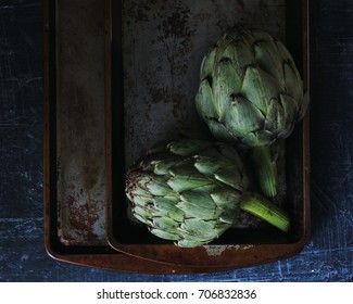 Artichokes With Iron Trays Background In Dark Food Photography Style