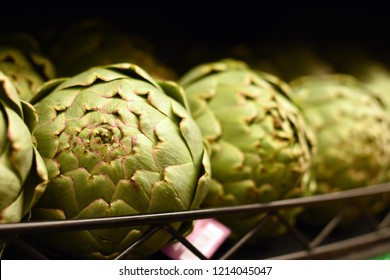 Artichokes In A Row On A Produce Aisle Shelf In The Grocery Store.  