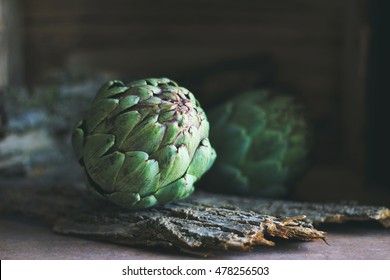 Artichokes With Wooden Background In Dark Food Photography Style