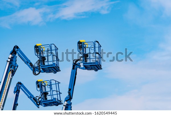Articulated boom lift. Aerial platform lift. Telescopic\
boom lift against blue sky. Mobile construction crane for rent and\
sale. Maintenance and repair hydraulic boom lift service. Crane\
dealership. 