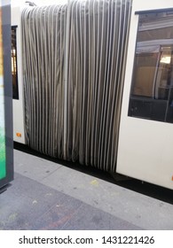 Articulated City Bus With Rubber Connection In The Form Of An Accordion Near The Street Bus Stop
