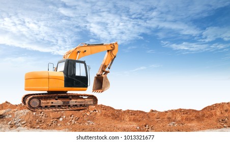 An articulated wheel crawler loader or dozer on mound with the industrial building construction site and blue sky background concept