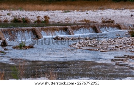 Artificial dam on the rivers, a stream of water in the form of a small waterfall, Texas, Garner State Park, USA