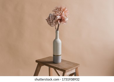 Artificial flowers in a vase. Studio photography of flowers. Decorative flowers with own hands. A minimalist bouquet of artificial flowers 