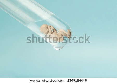 Artificial insemination. Test tube baby, IVF. A human embryo in a glass tube on a blue laboratory background. The concept of artificial insemination or human cloning.