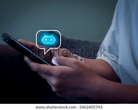Artificial intelligence, AI chat bot technology concept. Glowing smart robot icon on speech bubble on mobile phone screen in hands, robot application and conversation assistant automation service.