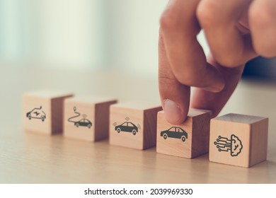 Artificial intelligence in autonomous car technology concept. A vehicle running self driving mode. Male hold wooden cube with autonomous car icon. Futuristic technology for the better human's life. 