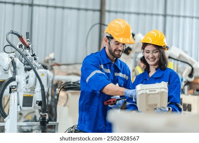 Artificial intelligence robotic technician concept, Factory engineer inspecting on machine with smart tablet. Worker works at heavy robot arm. Welding with remote system in an manufacturing industrial - Powered by Shutterstock