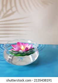 artificial lotus flower in the bowl with water. blue and white background.