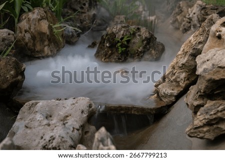 Artificial mist flows gently through rock-lined channels in the landscaped garden of TakeTime Glamping, Saraburi, Thailand, on August 11, 2025.