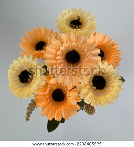 Artificial orange flower top view on table in cafe