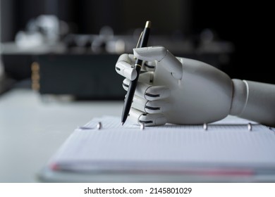 artificial robotic arm write down some notes with pen - Shutterstock ID 2145801029