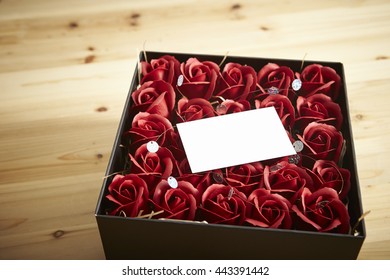 Artificial rose in box with note