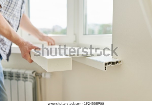 Artificial stone window sill,\
installation, technological process. Repair, construction of house,\
apartment. Close up of worker\'s hand with tools and\
parts