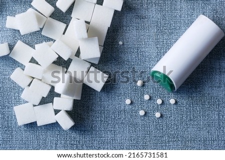 artificial sweetener and raw white sugar cube on table 