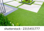 Artificial Turf with Gravel stone pavement decoration and green plant in Home Gardening area