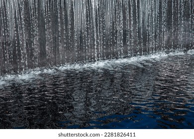 artificial waterfall with sunlit water droplets