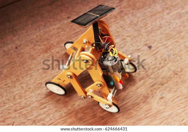Artificial wood car using solar panels placed\
on a brown\
background