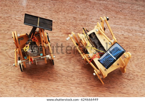 Artificial wood car using solar panels placed\
on a brown\
background