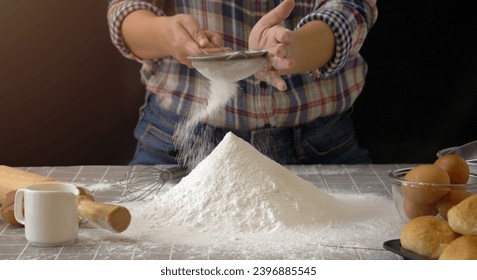 artisan bread working with dough. Use a sieve to sift flour into dough handmade bread with bakery equipment tools, black background. Bread-making process for baker at work. - Powered by Shutterstock