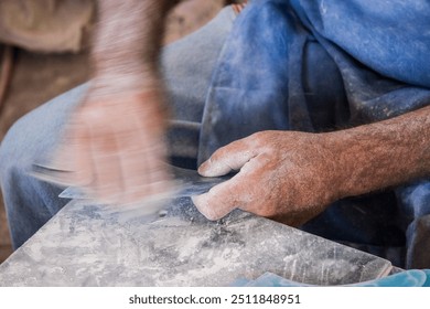 An artisan carefully shaping and crafting fins for surfboards, showcasing the traditional craftsmanship and skill involved in surfboard making. - Powered by Shutterstock