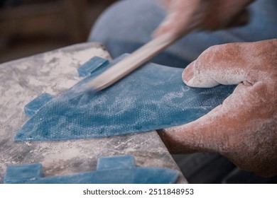 An artisan carefully shaping and crafting fins for surfboards, showcasing the traditional craftsmanship and skill involved in surfboard making. - Powered by Shutterstock