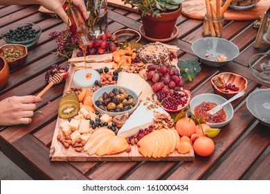 Artisan charcuterie boards hands with jam plates pomegranate grapes orange apricot cheese kiwi - Powered by Shutterstock