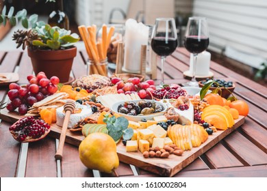 Artisan charcuterie boards kiwi grapes jam pomegranate olives cheese apricot kiwi orange almond food on the table - Powered by Shutterstock